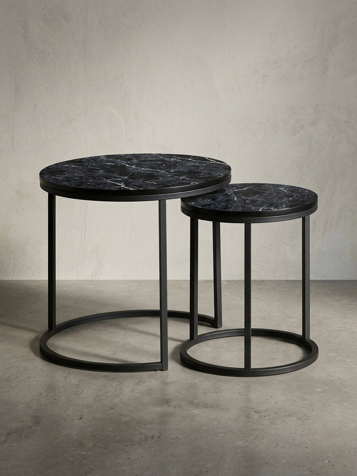 Design Beistelltisch 2er Set freigestellt auf weißem Hintergrund. Die runden Tische mit schwarzem Metallgestell und Tischplatte in Marmor-Optik sind klar zu sehen._