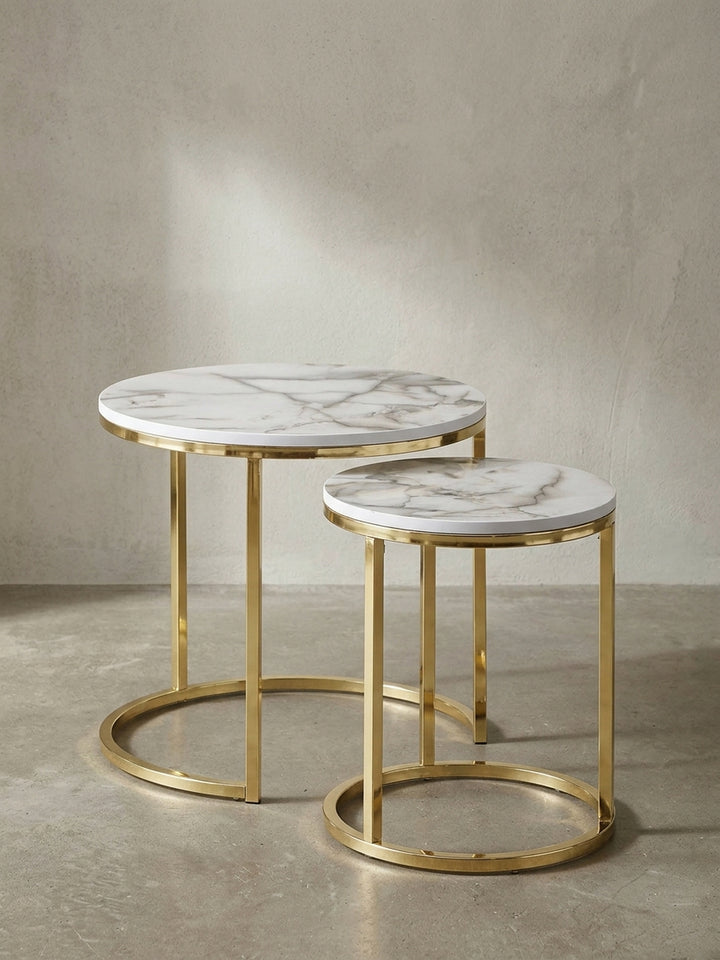Frontalansicht des zweiteiligen Satztisch-Sets in weißer Marmor-Optik mit glänzenden goldfarbenen Metallbeinen vor neutralem Hintergrund_