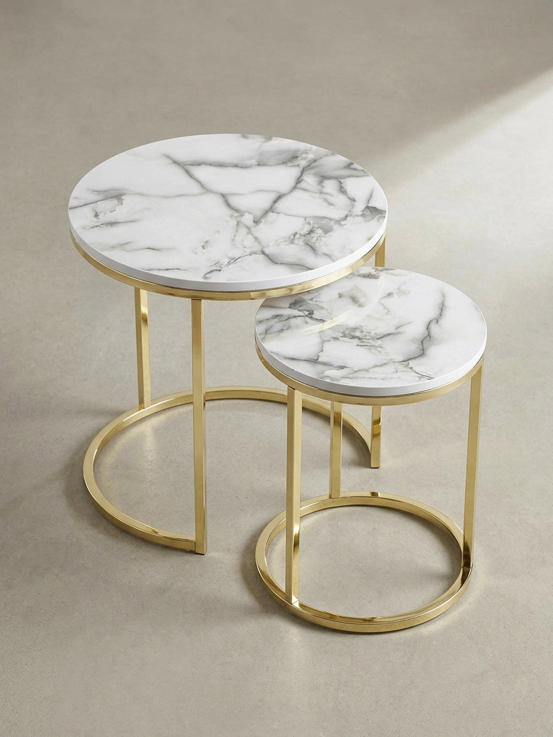 Detailaufnahme der Tischkante des Beistelltischs in eleganter Marmor-Optik mit nahtlosem Übergang zum glänzenden, gold lackierten Metallrahmen_
