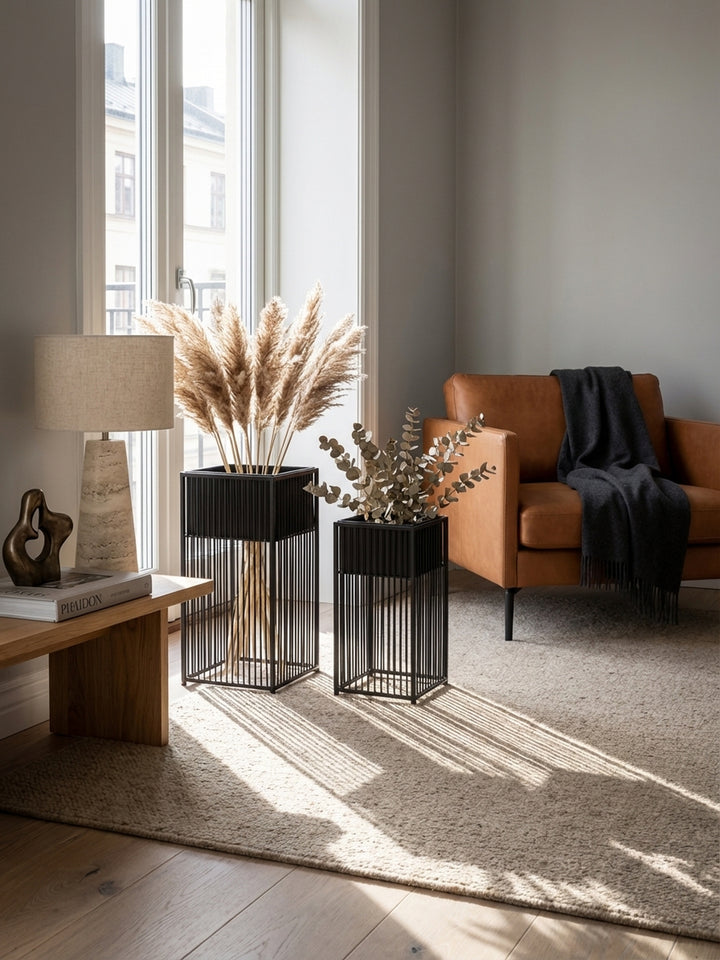 Detailansicht eines schwarzen Design-Blumentopfs mit weißen Trockenblumen, der eine elegante und minimalistische Dekoration für moderne Wohnräume schafft._