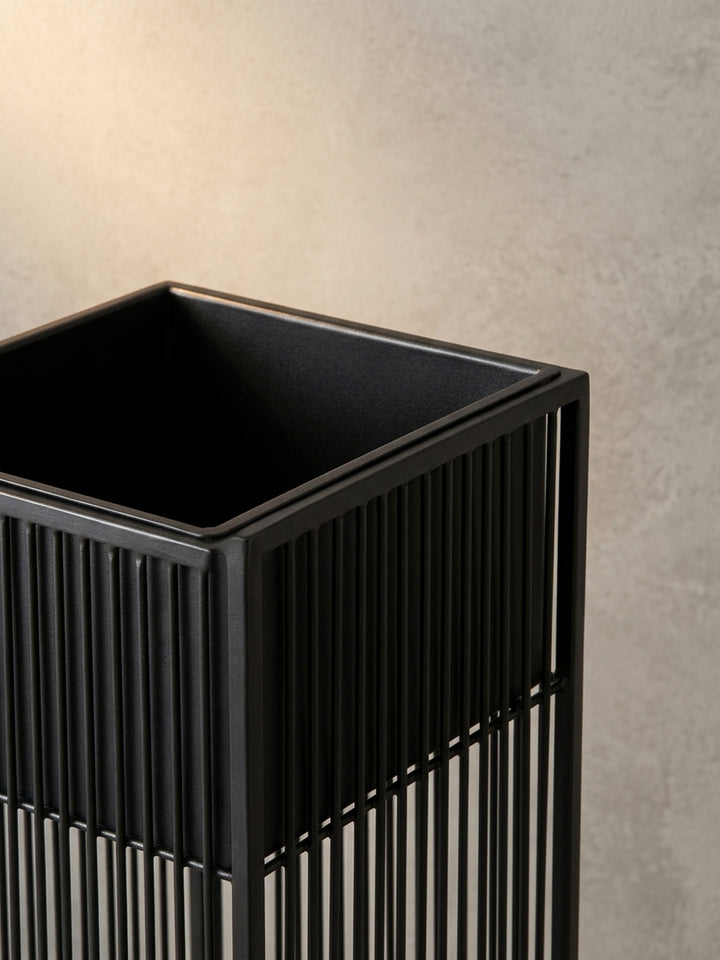 Alternatives Set schwarzer Design-Pflanzgefäße aus Metall, das die Vielseitigkeit für die Dekoration von Innenräumen wie Büro oder Flur unterstreicht._