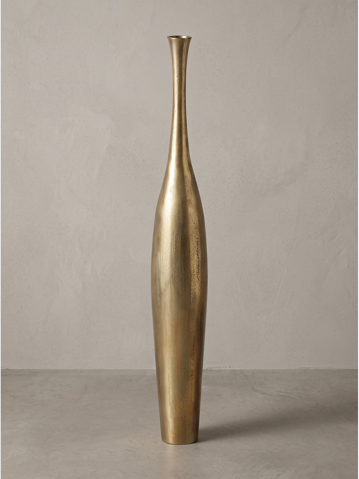 Schlanke Bodenvase Bottle S aus Aluminium goldfarben mit 13x13x75 cm Abmessungen freigestellt auf weißem Fotohintergrund._