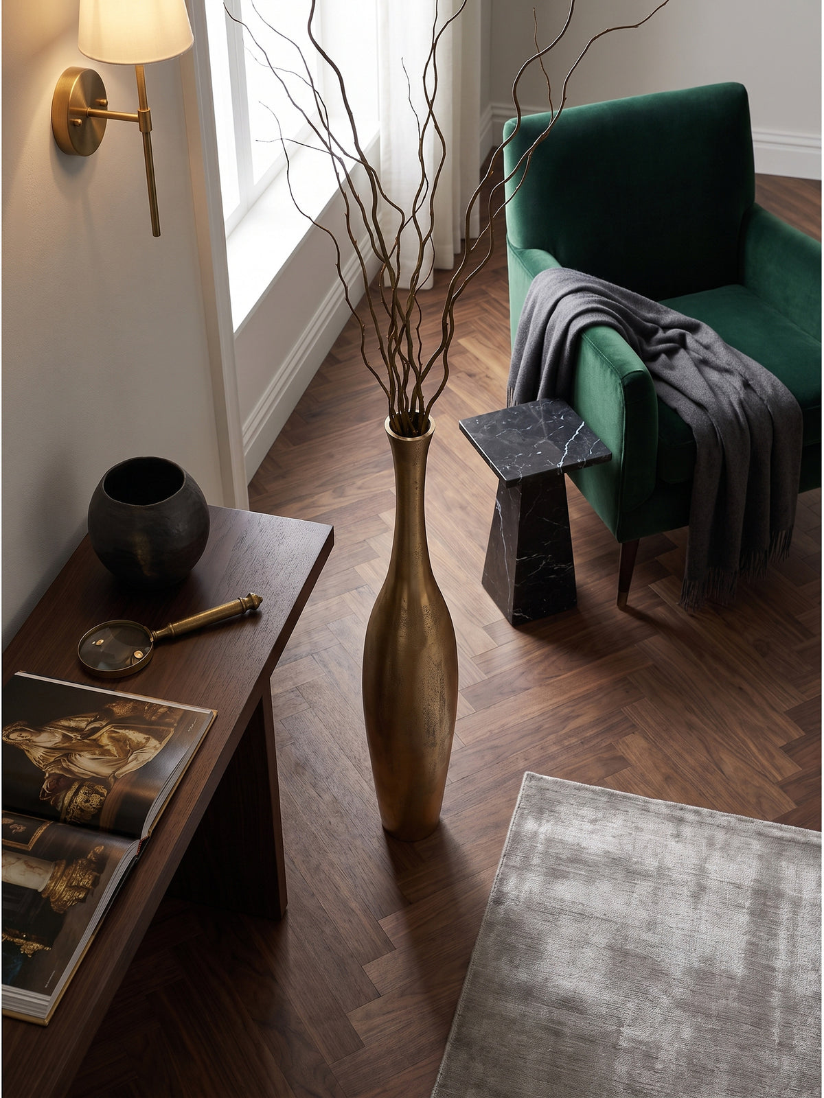 Blick von oben auf die strukturierte Raw-Finish Oberfläche der goldenen Dekovase neben einem Samtsessel auf einem Vintage-Perserteppich.