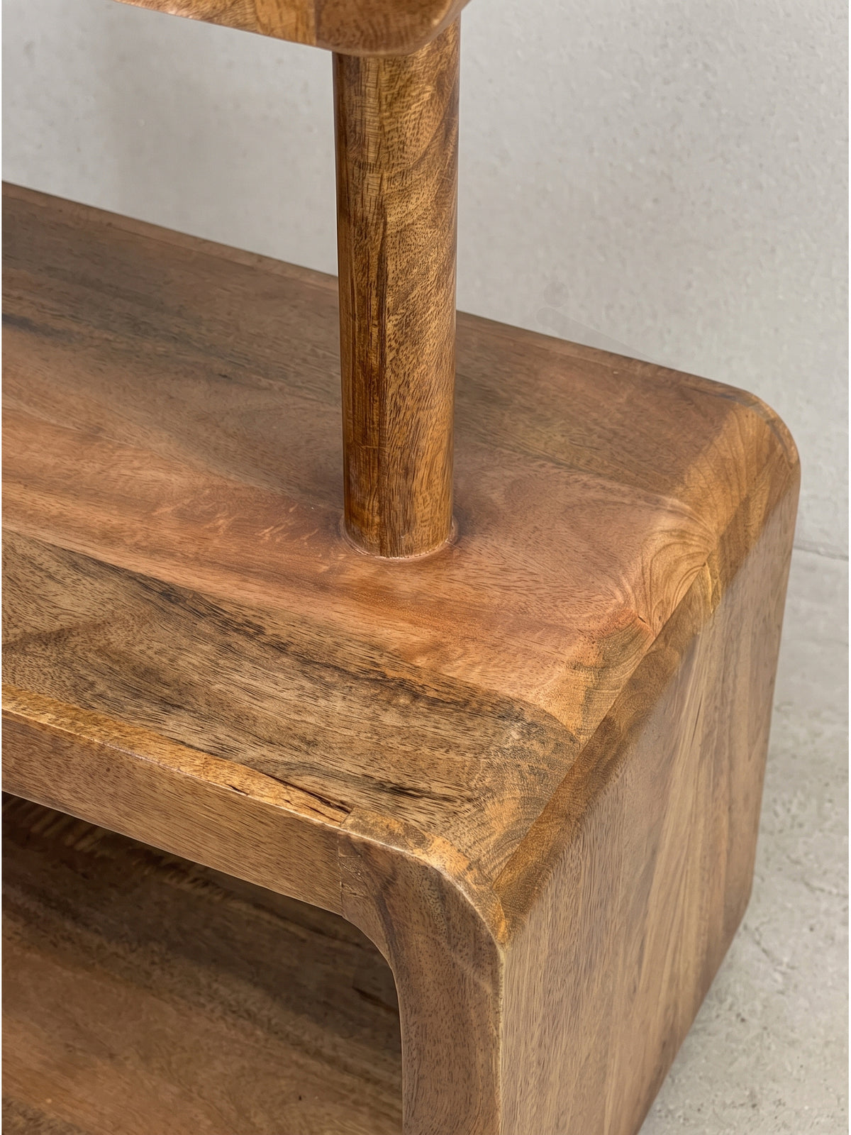 Schrägansicht des Mango Holzregals aus tieferer Perspektive, die die Stabilität der 5 cm dicken Bodenplatte hervorhebt_