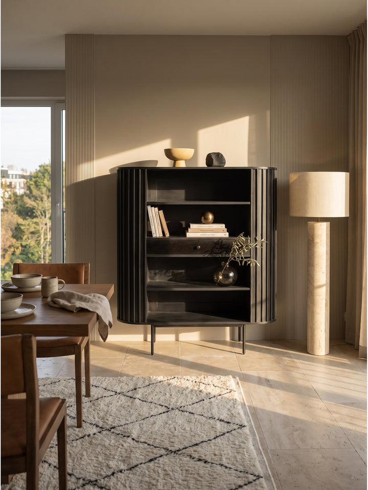 Schwarzes Bücherregal aus Mangoholz 105x40x122 cm mit geriffelten Lamellen im eleganten Wohnzimmer auf hellem Travertinsteinboden_