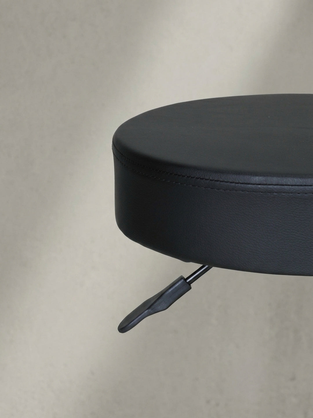 Detailansicht der stabilen Basis vom kompakten Sitzhocker, robuster schwarzer Kunststoff und spezielle Leichtlaufrollen, welche ideal für glattes Parkett oder hartes Laminat geeignet sind._