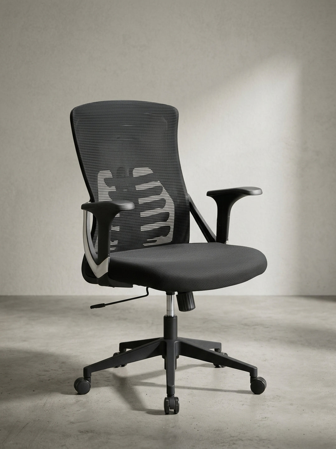 Seitenprofil eines schwarzen Drehstuhls mit Lendenwirbelstütze und Armlehnen, der für eine gesunde Sitzhaltung am Arbeitsplatz sorgt._
