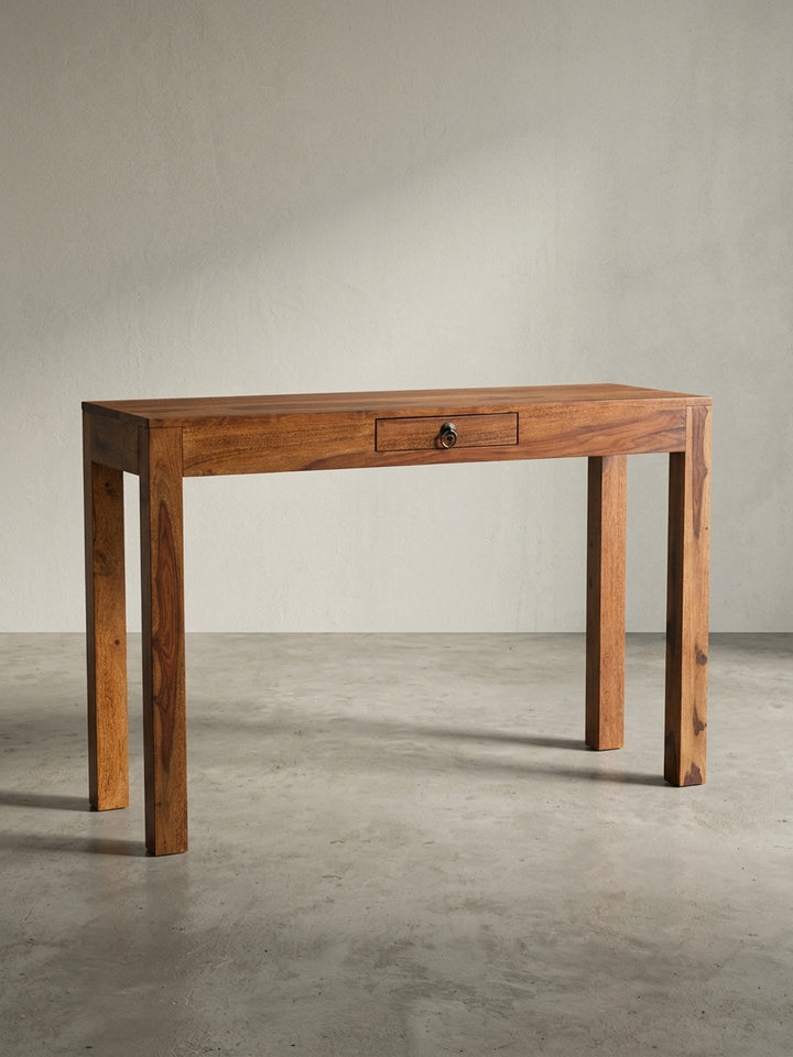 Platzsparender Homeoffice-Schreibtisch aus dunklem Sheesham-Holz in der 3/4-Ansicht, die die Tiefe und die massive Bauweise zeigt._