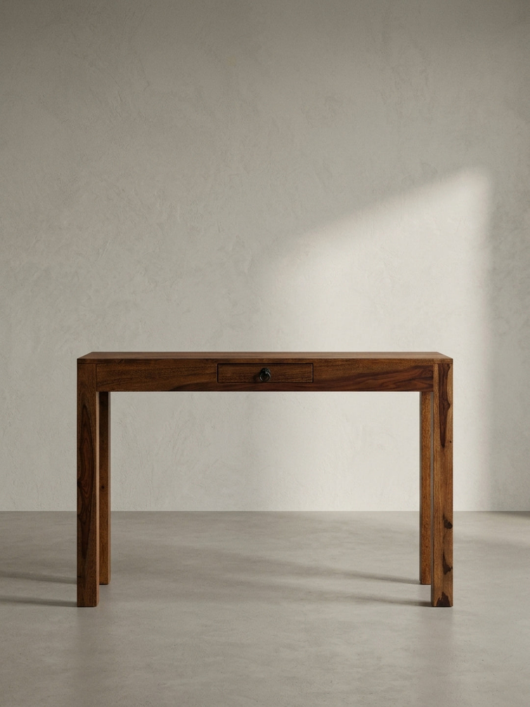 Eleganter Schreibtisch aus massivem Sheesham-Holz mit einer Schublade und dunklem Metallgriff, frontale Ansicht auf weißem Hintergrund._