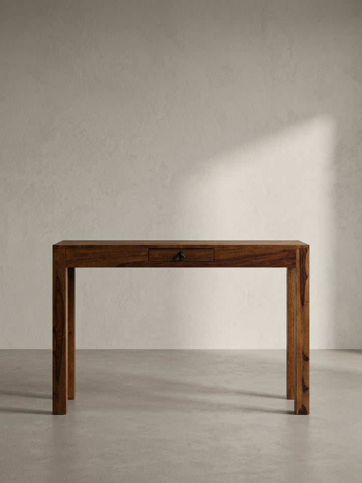 Eleganter Schreibtisch aus massivem Sheesham-Holz mit einer Schublade und dunklem Metallgriff, frontale Ansicht auf weißem Hintergrund._