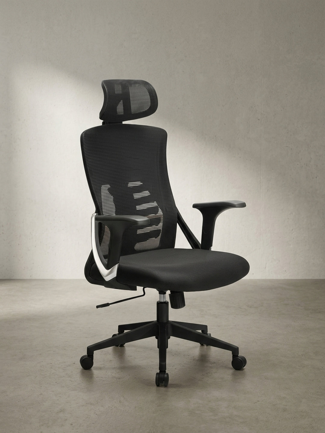 Seitenansicht des schwarzen Bürodrehstuhls, welche die s-förmige ergonomische Rückenlehne und die weiche Netzbespannung für den Arbeitsalltag hervorhebt._