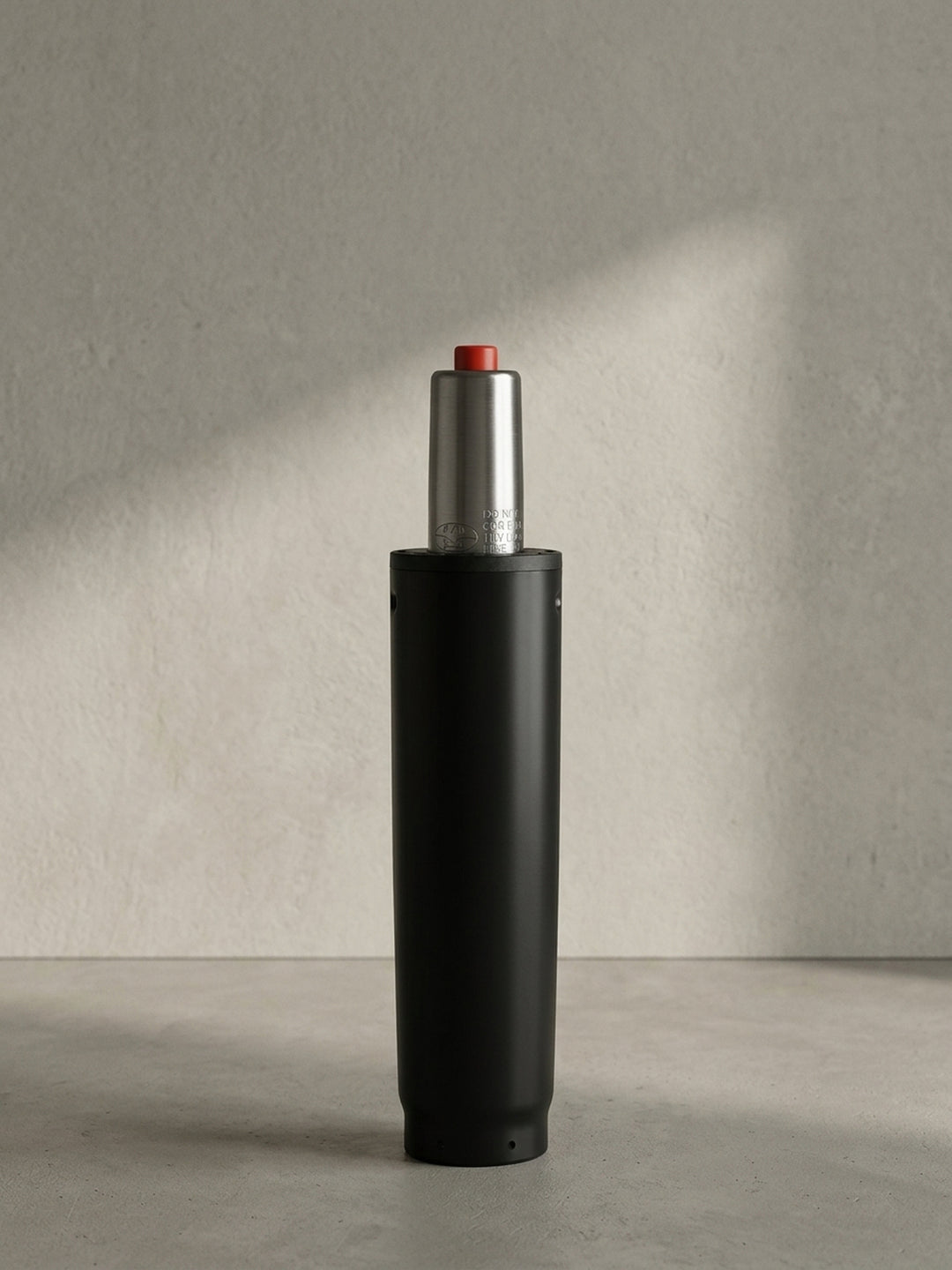 Die komplett freigestellte Gasdruckfeder präsentiert sich in der Vorderansicht mit dem mattschwarzen 50-mm-Gehäuse und dem silbernen, genormten Zylinderaufsatz._