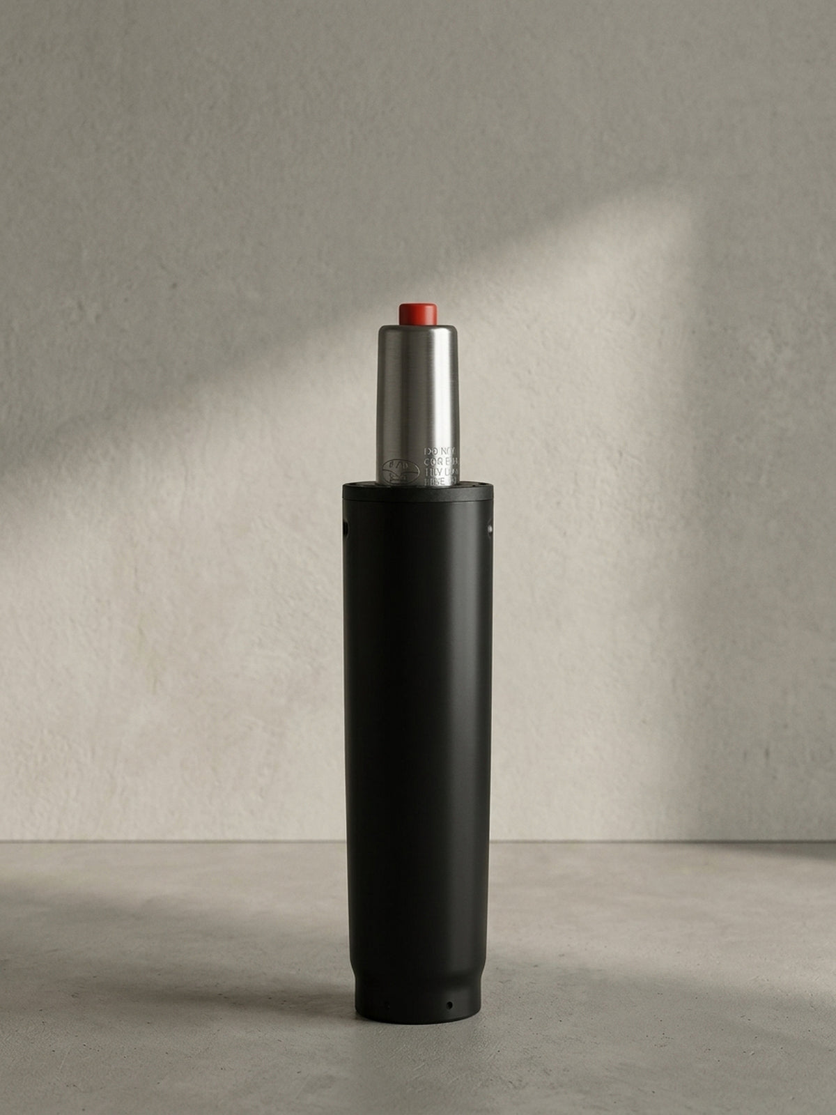 Die komplett freigestellte Gasdruckfeder präsentiert sich in der Vorderansicht mit dem mattschwarzen 50-mm-Gehäuse und dem silbernen, genormten Zylinderaufsatz._