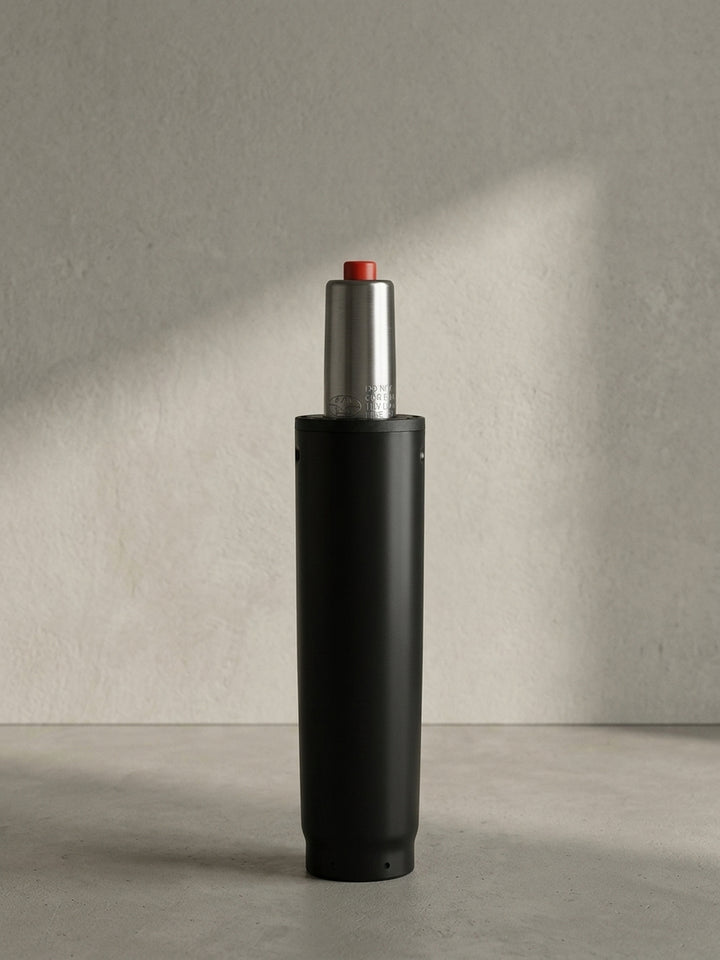Die komplett freigestellte Gasdruckfeder präsentiert sich in der Vorderansicht mit dem mattschwarzen 50-mm-Gehäuse und dem silbernen, genormten Zylinderaufsatz._