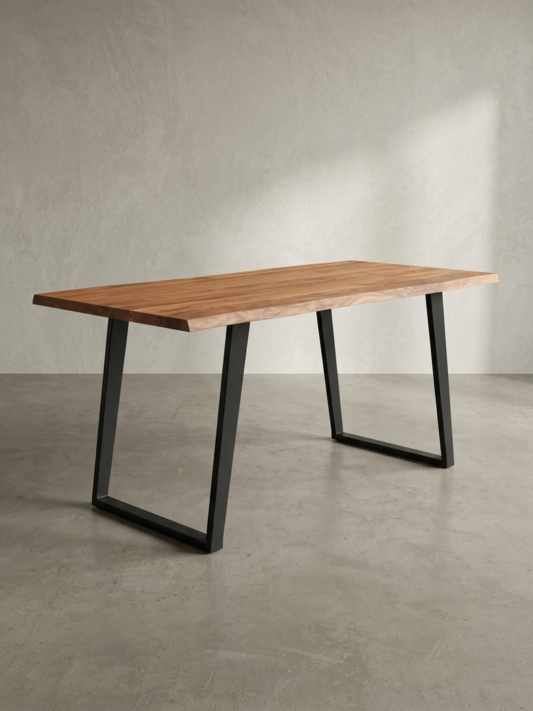 Seitenansicht des Bürotisches, die klare Silhouette der 4 cm dicken Massivholzplatte und das minimalistische Profil der schwarzen Metallkufen wird sichtbar._