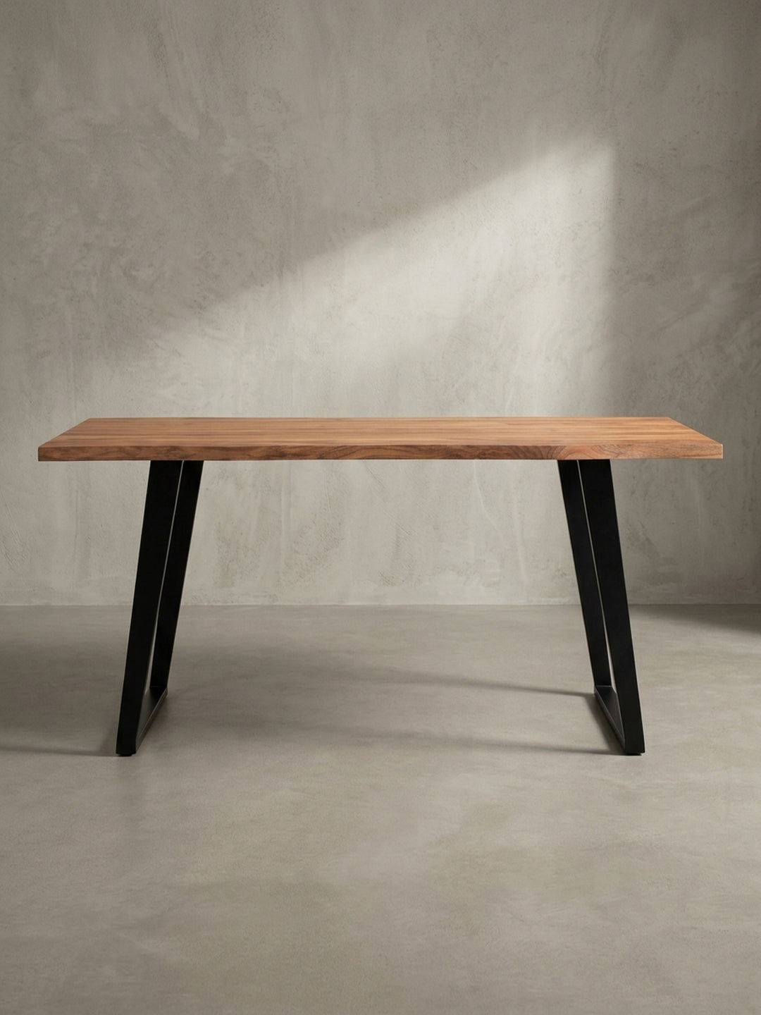 Schreibtisch aus Akazie Massivholz in einer 3/4-Ansicht, die die Tiefe der 4 cm starken Tischplatte und das schlanke Design der Metallbeine zeigt._