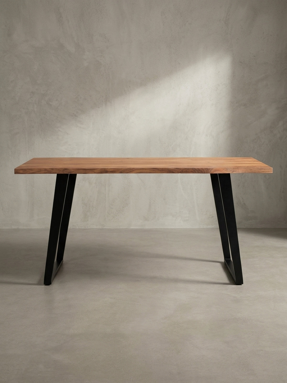Schreibtisch aus Akazie Massivholz in einer 3/4-Ansicht, die die Tiefe der 4 cm starken Tischplatte und das schlanke Design der Metallbeine zeigt.