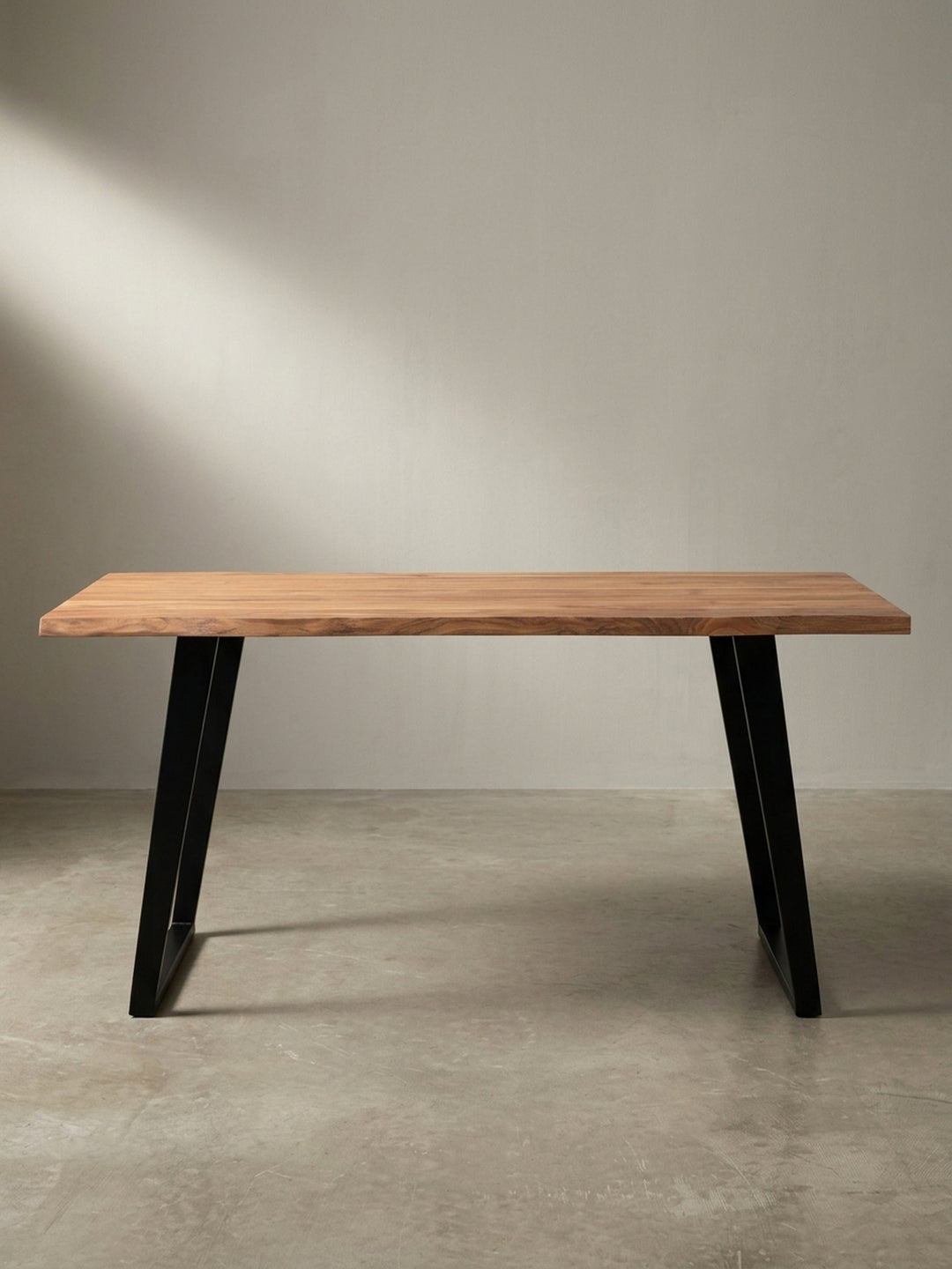 Schreibtisch im Industrial-Design aus Akazie und Metall in einer schrägen 3/4-Ansicht vor weißem Hintergrund._