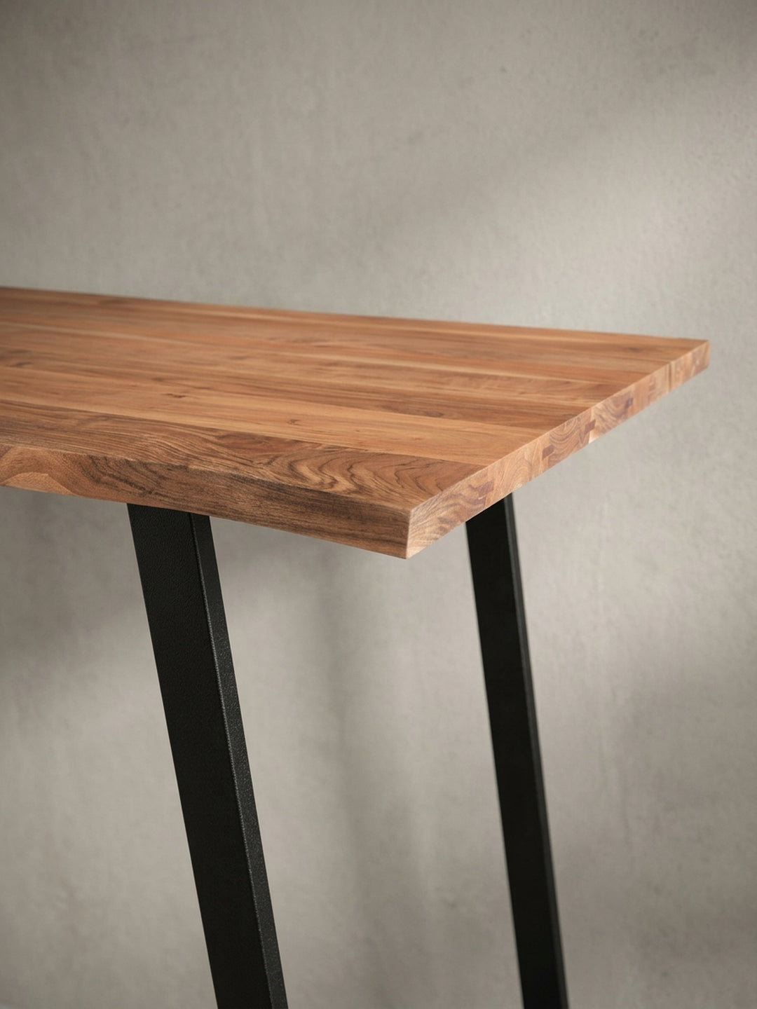 Perspektivische Ansicht des Holztisches für das Arbeitszimmer, die das Zusammenspiel von warmer Holzoberfläche und kühlem Metallgestell betont._