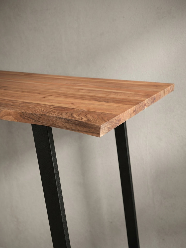 Perspektivische Ansicht des Holztisches für das Arbeitszimmer, die das Zusammenspiel von warmer Holzoberfläche und kühlem Metallgestell betont._