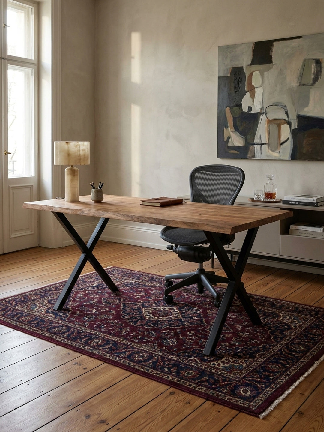 Der Holztisch aus Akazie mit Baumkante wird als Homeoffice-Arbeitsplatz mit einem ergonomischen schwarzen Bürostuhl auf einem hellen Teppich kombiniert._
