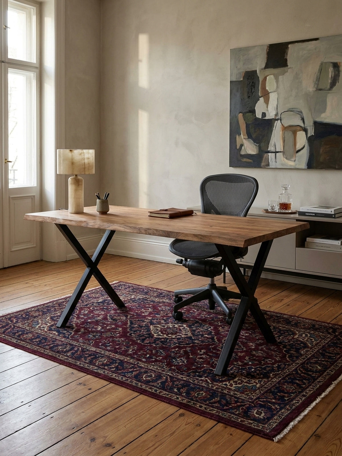 Der Holztisch aus Akazie mit Baumkante wird als Homeoffice-Arbeitsplatz mit einem ergonomischen schwarzen Bürostuhl auf einem hellen Teppich kombiniert.