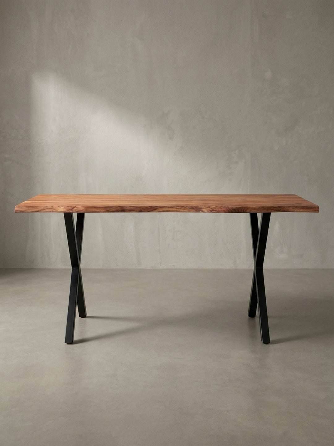 Schreibtisch im Industrial-Design aus schräger Perspektive, die die 4 cm dicke Tischplatte aus Akazie und das stabile Metallgestell in Schwarz zeigt._