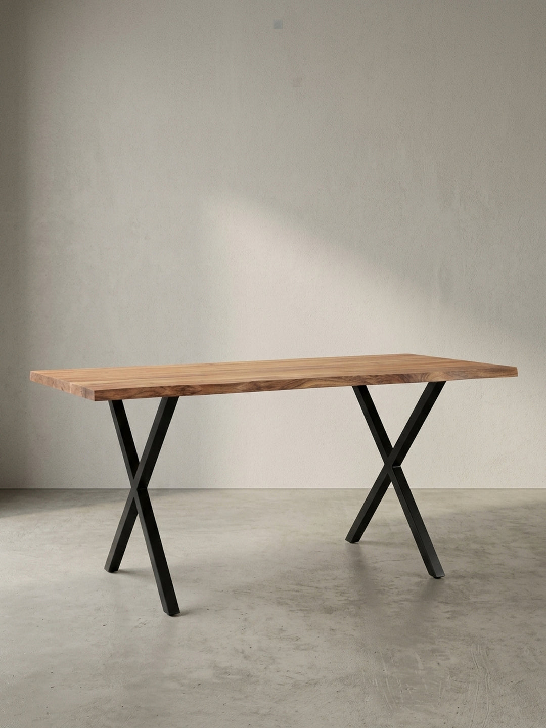 Freigestellter Schreibtisch aus massivem Akazienholz mit charakteristischer Baumkante und stabilen, schwarzen X-Beinen aus Metall, Frontalansicht._