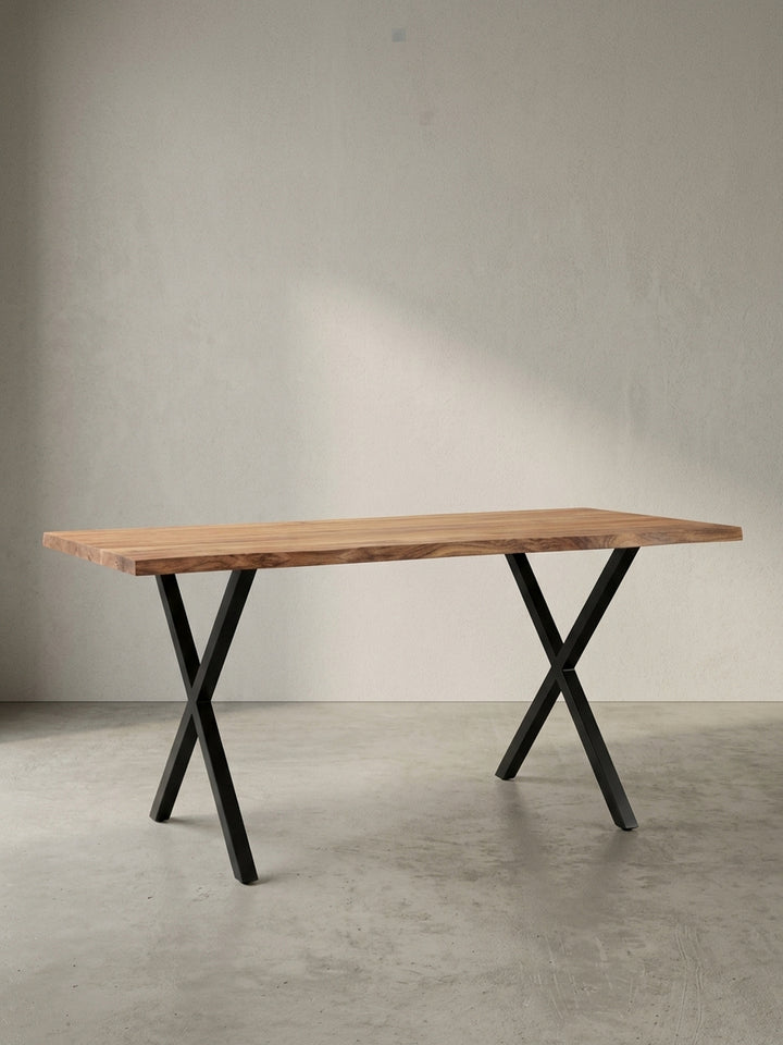 Freigestellter Schreibtisch aus massivem Akazienholz mit charakteristischer Baumkante und stabilen, schwarzen X-Beinen aus Metall, Frontalansicht._
