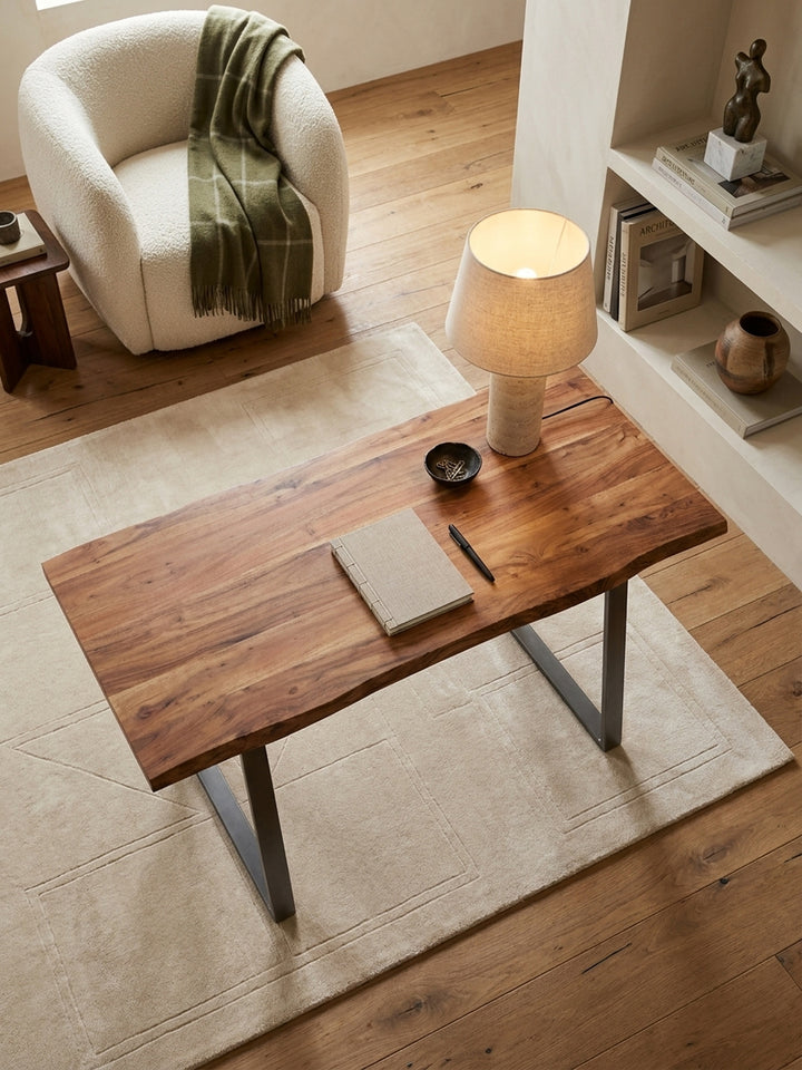 Draufsicht auf den Homeoffice-Arbeitsplatz mit dem Holztisch aus Akazie und Metallbeinen auf einem modernen Teppich._