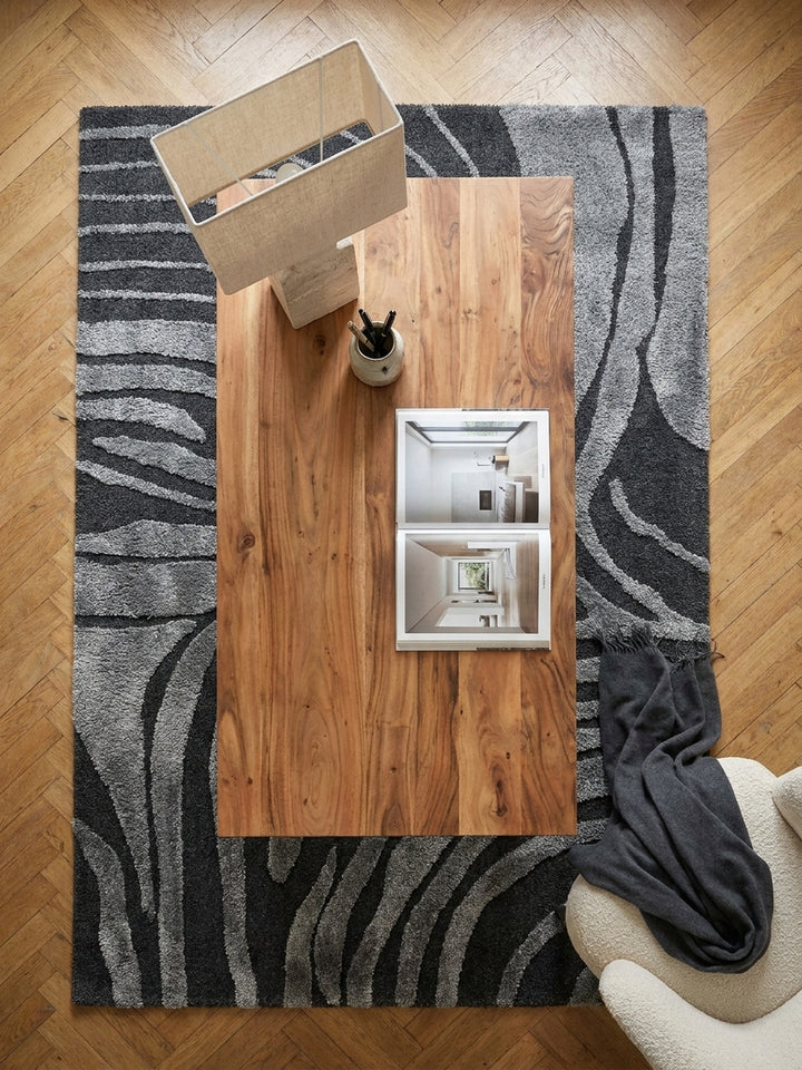 Draufsicht auf den Massivholz-Schreibtisch 160x80 cm, arrangiert mit ergonomischem Stuhl und Vintage-Perserteppich im Arbeitszimmer._
