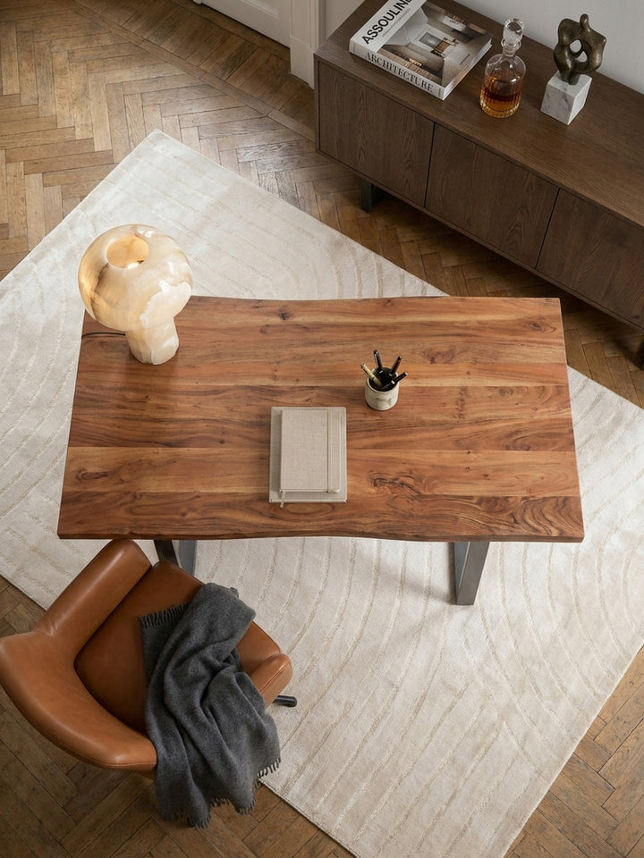 Draufsicht auf einen 180x90 cm Massivholz-Schreibtisch in einem elegant eingerichteten Arbeitszimmer, der reichlich Platz für kreatives Arbeiten bietet._
