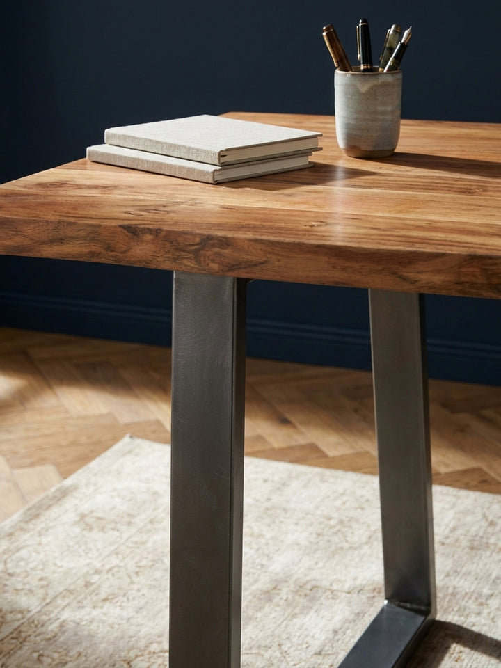 Detailaufnahme der lebendigen Maserung und der warmen Farbe des Akazienholzes der Schreibtischplatte mit Klarlack-Finish._