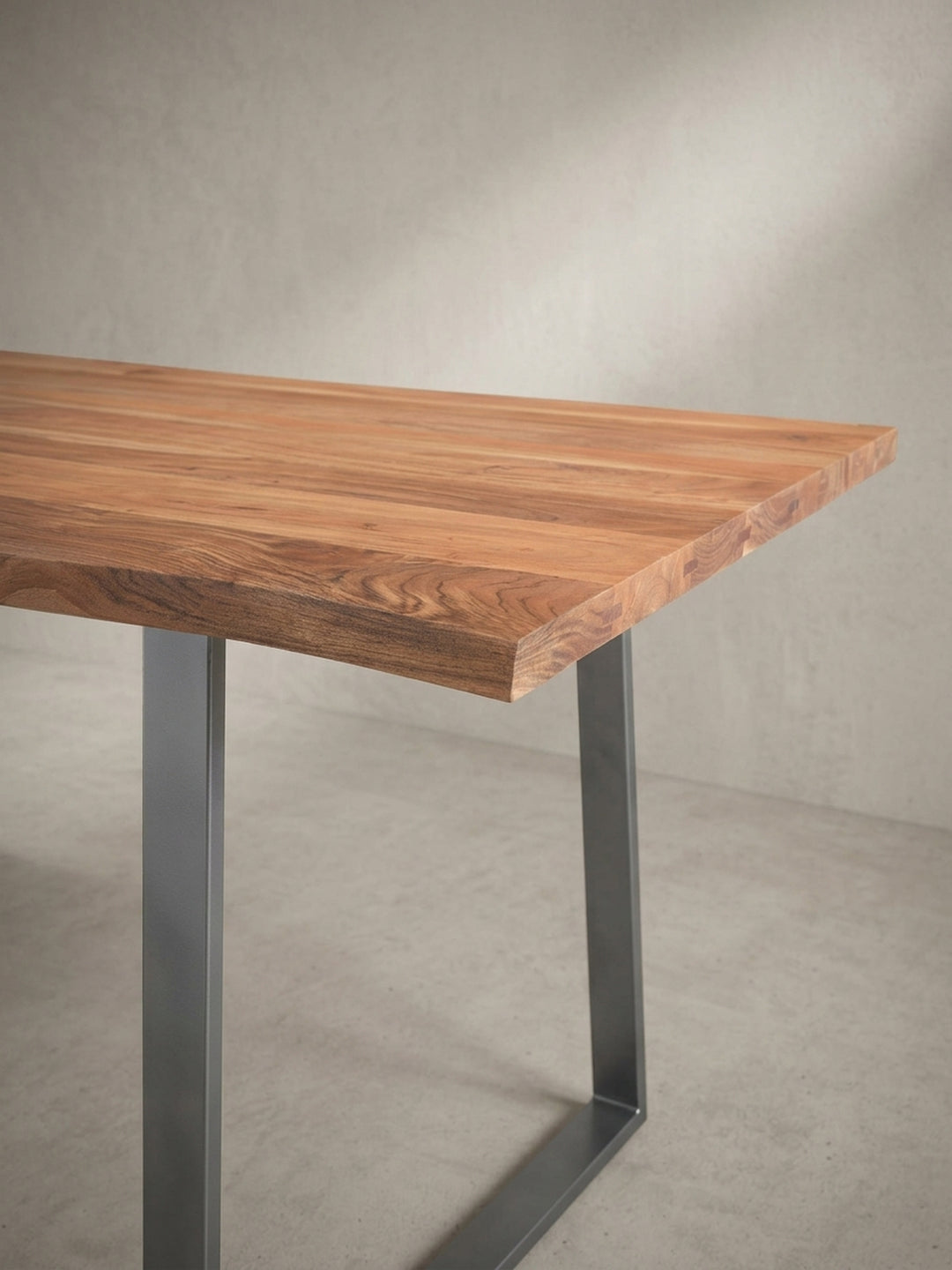 Eine alternative Perspektive auf den Homeoffice-Tisch, die das Zusammenspiel von der organischen Holzkante und den klaren Linien des Metallgestells aus einem anderen Winkel beleuchtet._
