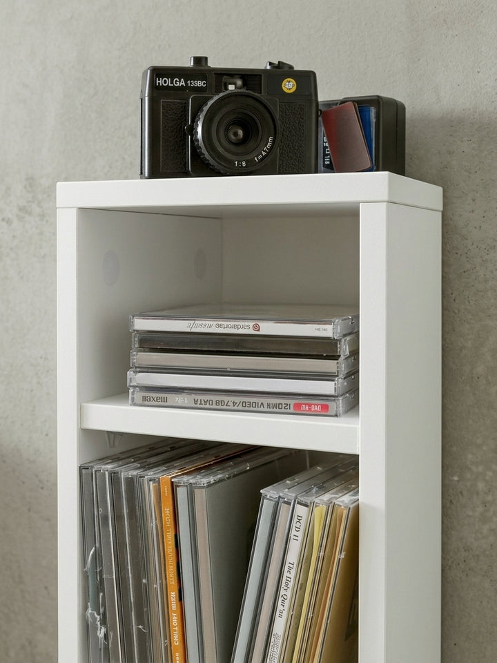 Gesamtübersicht des schmalen Aufbewahrungsregals für CDs und DVDs. Das puristische weiße Design macht dieses Stehregal zu einem zeitlosen Möbelstück für jedes Arbeitszimmer._