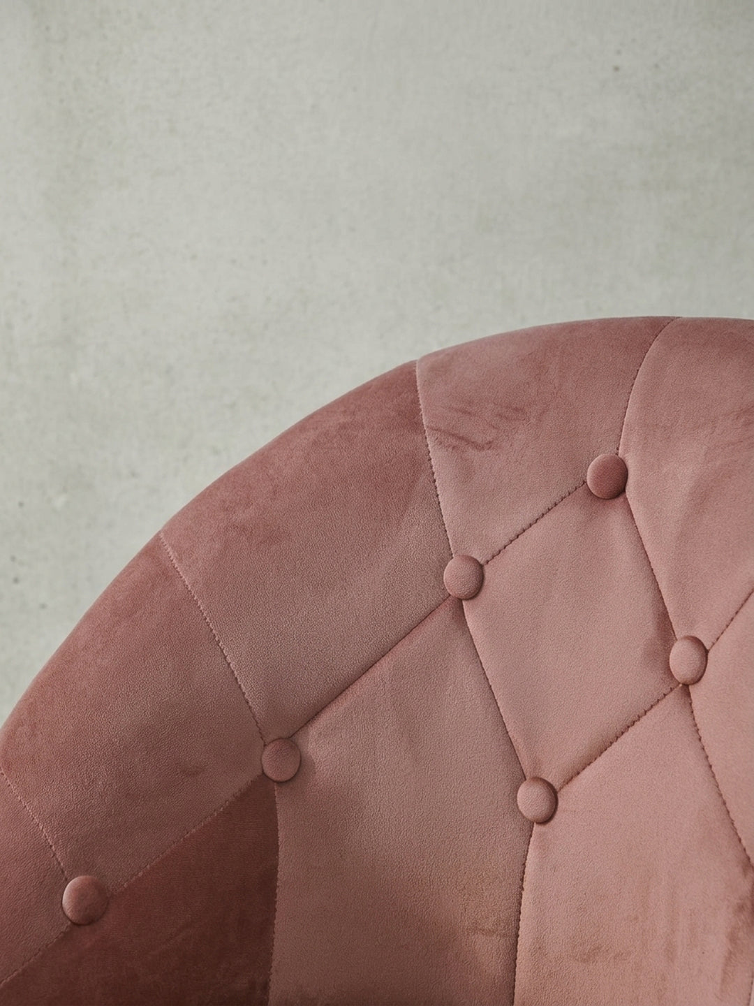 Detailaufnahme des goldenen Standfußes und des Verstellhebels des rosa Samtsessels, die die matte Lackierung des Metalls und die Funktionalität des Designs zeigen._