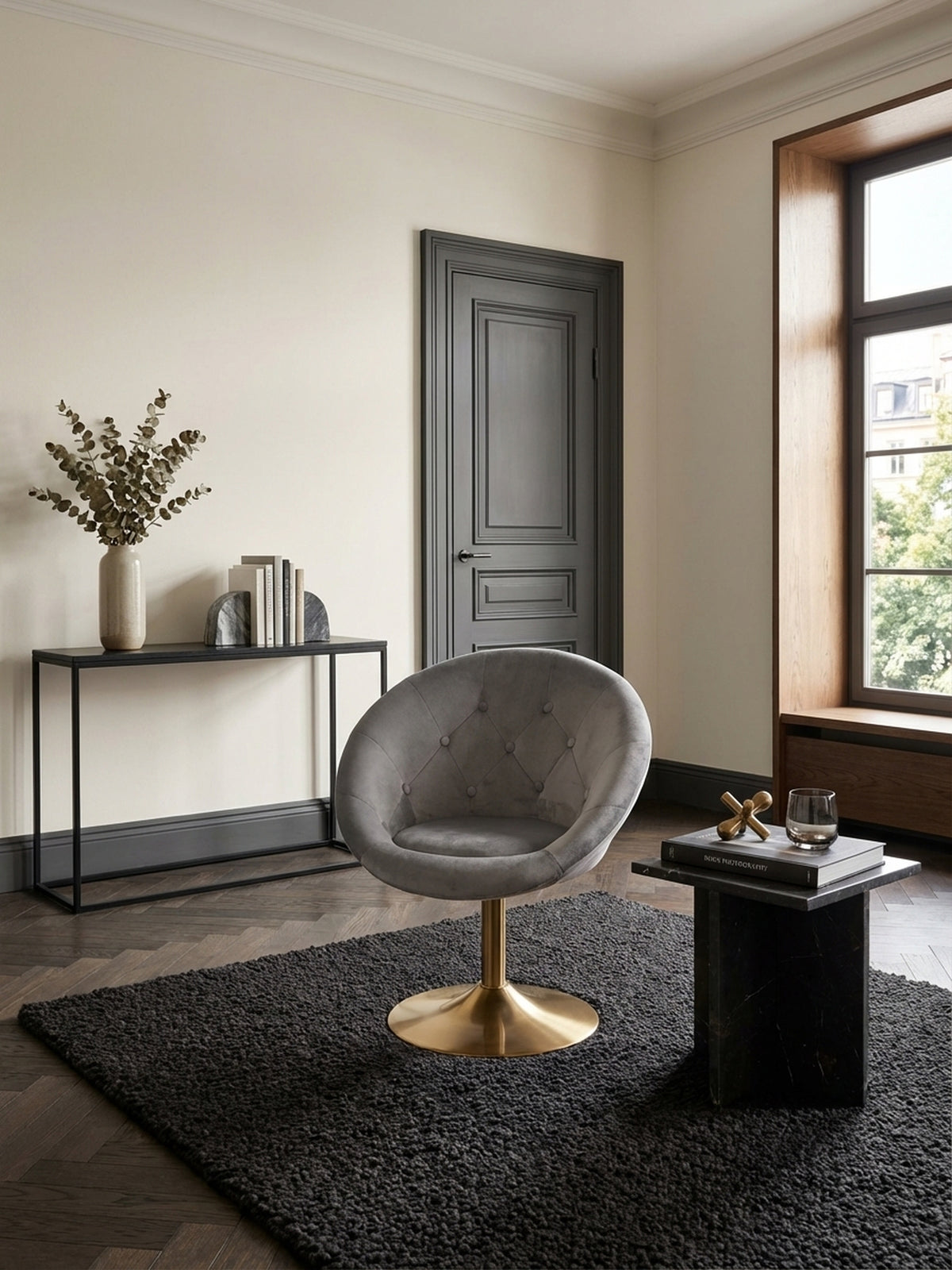 Eleganter Loungesessel in Samt Grau mit goldenem Fuß, stilvoll in einem hellen Wohnzimmer mit Parkett und einem dezenten Teppich als Lese-Ecke inszeniert.