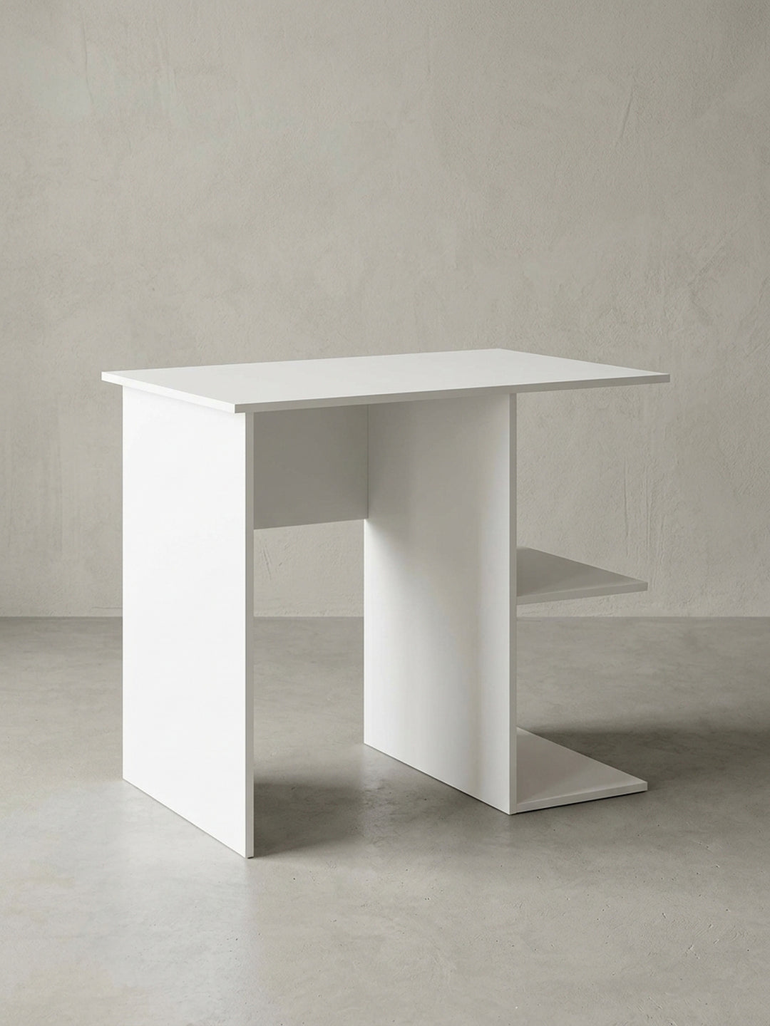 Freistehender kleiner Schreibtisch in Weiß vor neutralem Hintergrund. Der 82x60x76cm große Computertisch besticht durch sein minimalistisches Design mit zwei praktischen Regalablagen._