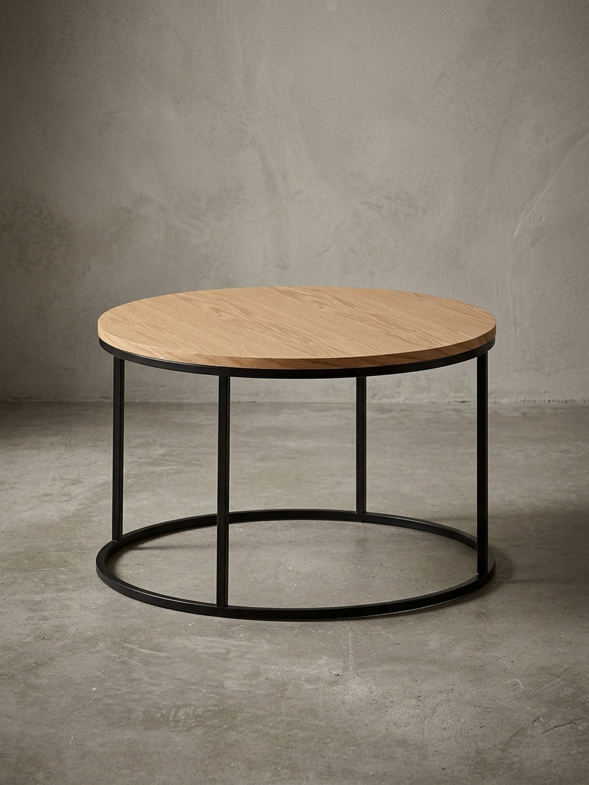 Moderner runder Couchtisch (70 cm Durchmesser) mit Eichenfurnier-Tischplatte und schwarzem Stahlgestell, freigestellt vor weißem Hintergrund aus frontaler Ansicht.