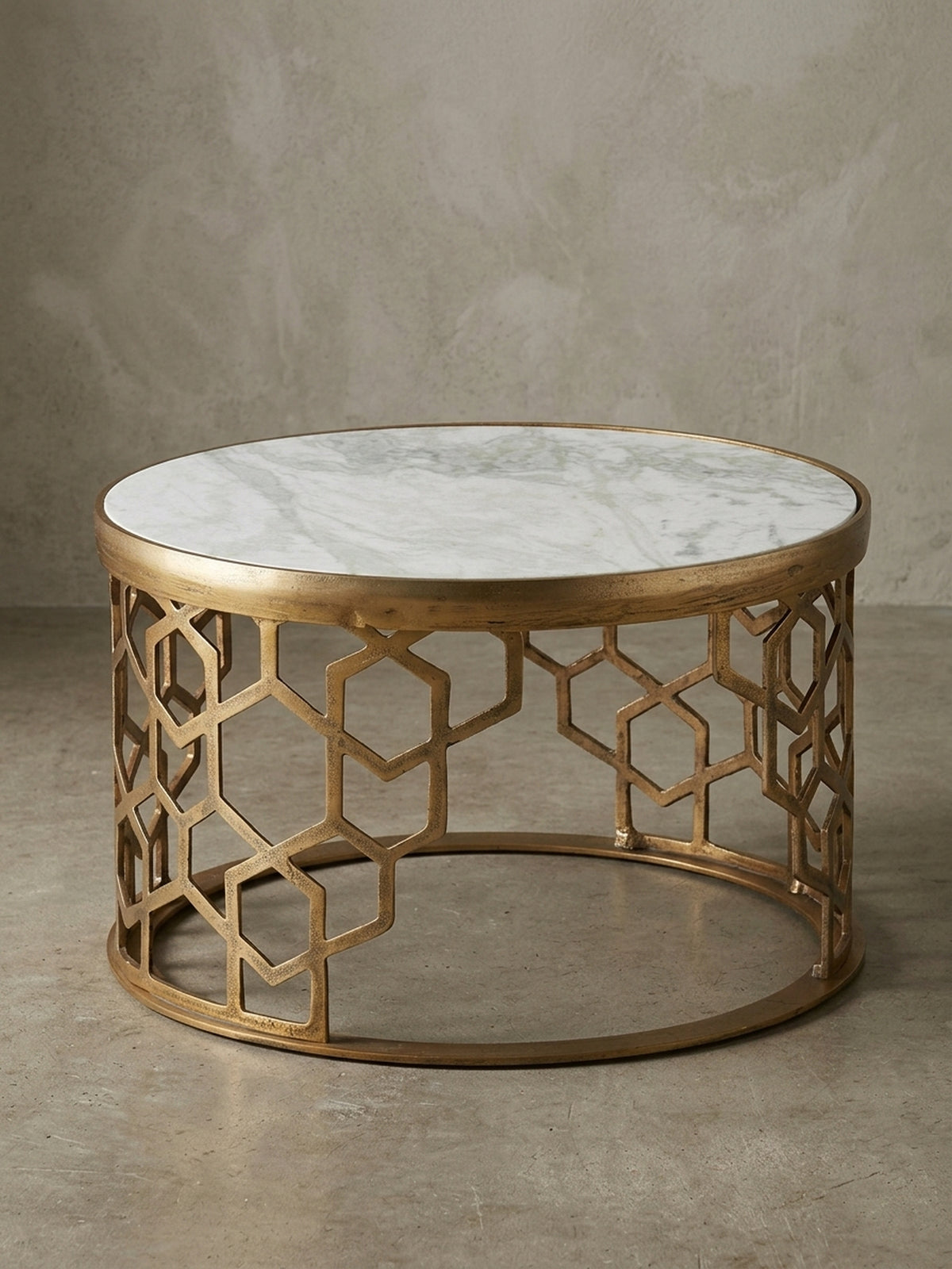 Runder Design-Couchtisch (60 cm) mit weißer Marmorplatte und goldenem Aluminiumgestell mit Wabenmuster, freigestellt vor neutralem Hintergrund in der Vorderansicht._