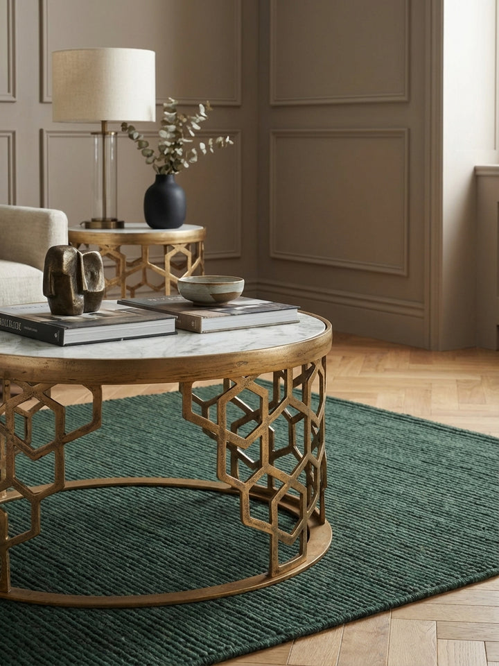 Nahaufnahme der echten Marmor-Tischplatte mit ihrer einzigartigen grauen Maserung und der texturierten, goldfarbenen Oberfläche des filigranen Metallgestells._