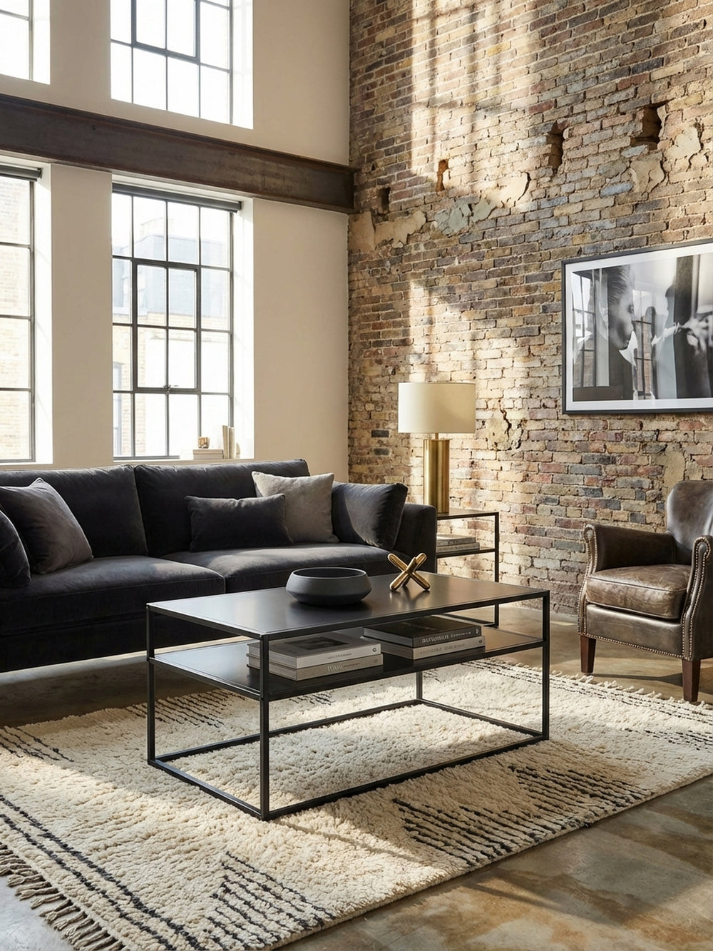 Schwarzer Industrial Couchtisch aus Metall im Wohnzimmer vor einem beigen Sofa, dekoriert mit Büchern auf einem hellen Teppich mit Streifen._