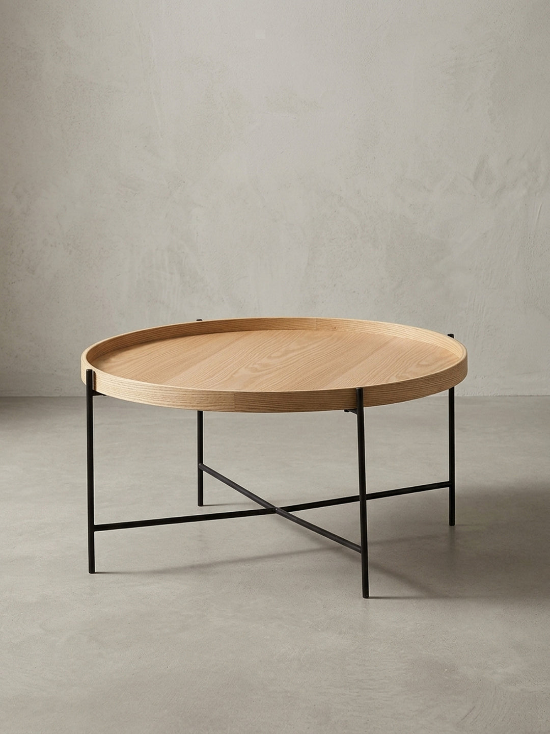 Moderner runder Couchtisch mit 78 cm Durchmesser vor weißem Hintergrund, mit heller Eichenholz-Tischplatte und elegantem, schwarzem Metallgestell in Kreuzform._