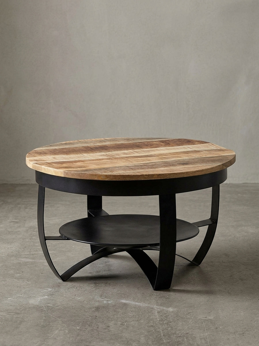 Freigestellter Couchtisch im Industrial-Stil, runde Form, mit Tischplatte aus Mango-Massivholz und schwarzem Metallgestell, Frontansicht._