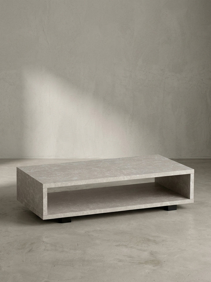 Freigestellte Frontansicht des 100 cm breiten, sandfarbenen Couchtisches in Stein-Optik, der sein geradliniges Design präsentiert._