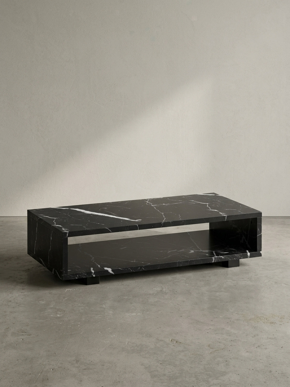 Vorderansicht des rechteckigen Couchtisches 100x50x25 cm aus schwarzem MDF mit Marmordekor, schwebend durch verdeckte Füße vor neutralem weißen Hintergrund_
