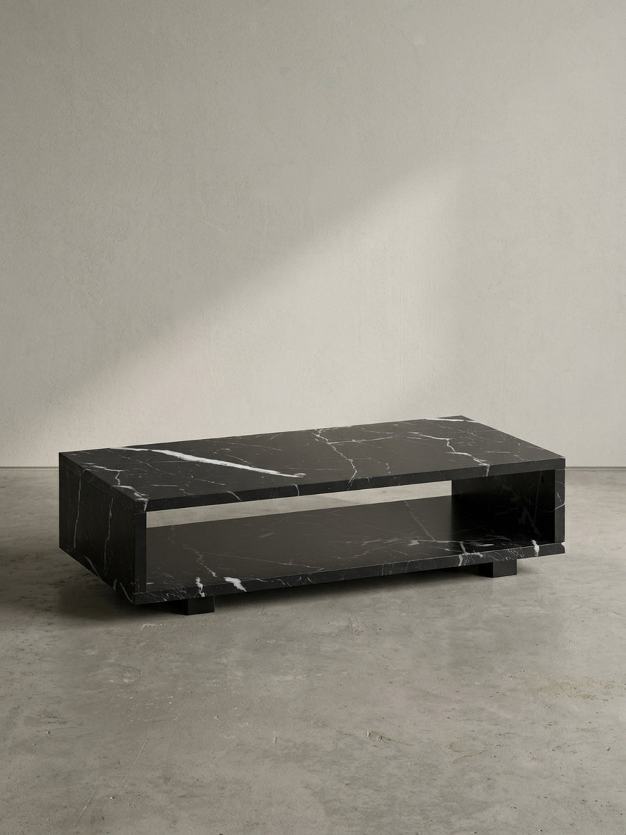 Vorderansicht des rechteckigen Couchtisches 100x50x25 cm aus schwarzem MDF mit Marmordekor, schwebend durch verdeckte Füße vor neutralem weißen Hintergrund_