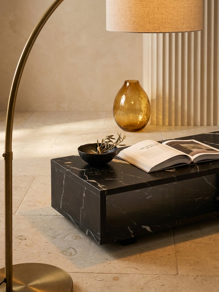 Niedriger Loungetisch mit integriertem Stauraum, elegant dekoriert mit dicken Architektur-Bildbänden und einer handgetöpferten Keramikvase neben einem Sessel_