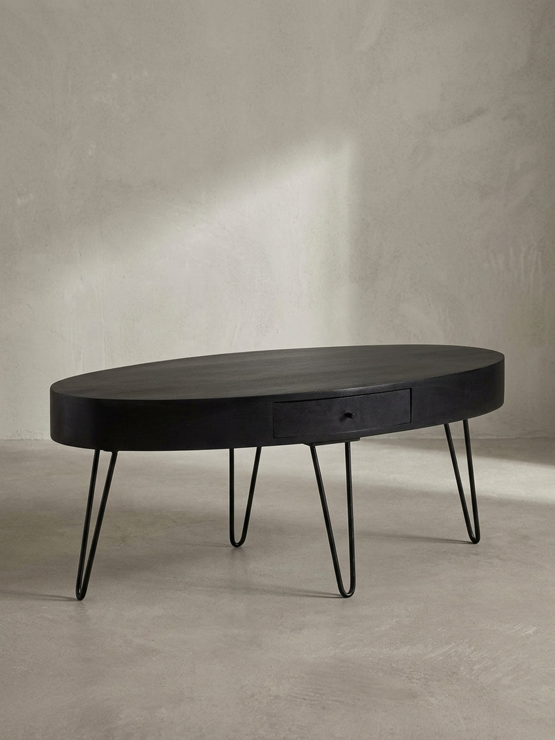 Nahaufnahme des dezenten schwarzen Schubladengriffs am Couchtisch, ein Detail, das Funktionalität und minimalistisches Design vereint._