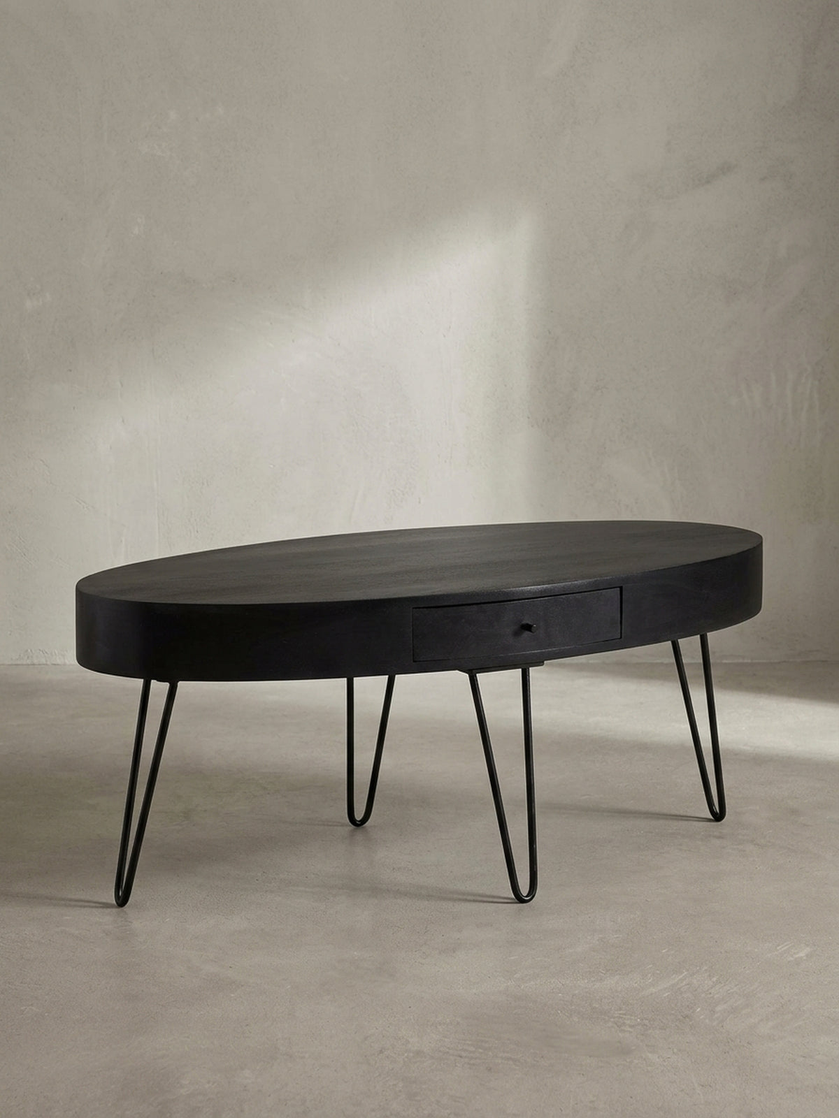 Nahaufnahme des dezenten schwarzen Schubladengriffs am Couchtisch, ein Detail, das Funktionalität und minimalistisches Design vereint.